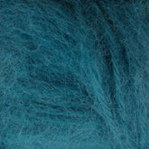 A close-up image of blue Plymouth Baby Alpaca Brush yarn fibers, crafted by Plymouth Yarn Co., forming a soft, fluffy, and textured surface reminiscent of cozy alpaca sweaters. The threads overlap and intertwine, creating a somewhat fuzzy appearance with visible fibers extending in various directions.