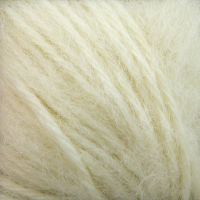 Close-up of soft, ivory-colored Plymouth Baby Alpaca Brush fibers by Plymouth Yarn Co. The texture is fluffy and slightly tangled, evoking warmth and coziness reminiscent of alpaca sweaters. The fibers vary in thickness, creating a natural and organic appearance.