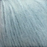 Close-up image of a skein of Plymouth Baby Alpaca Brush by Plymouth Yarn Co. This soft, fuzzy light blue yarn features slightly fluffy fibers wound tightly in a spiral pattern. It's perfect for creating cozy blankets or luxurious alpaca accessories.