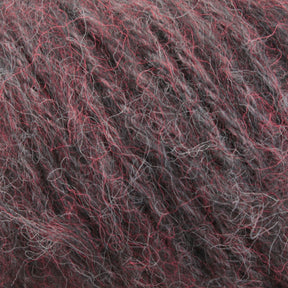 Close-up of a ball of Plymouth Baby Alpaca Brush yarn by Plymouth Yarn Co. with a color mix of dark gray, light gray, and subtle red fibers intertwined. The texture appears soft and woolly, reminiscent of alpaca sweaters, making it perfect for knitting cozy blankets or other luxurious alpaca accessories.