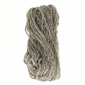 A skein of Jöklalopi (Bulky Lopi) from Berroco, Inc. is coiled in a loose bundle against a white background. The thick, gray yarn appears soft and slightly fuzzy, making it perfect for knitting chunky winter sweaters or other cozy projects in natural shades.