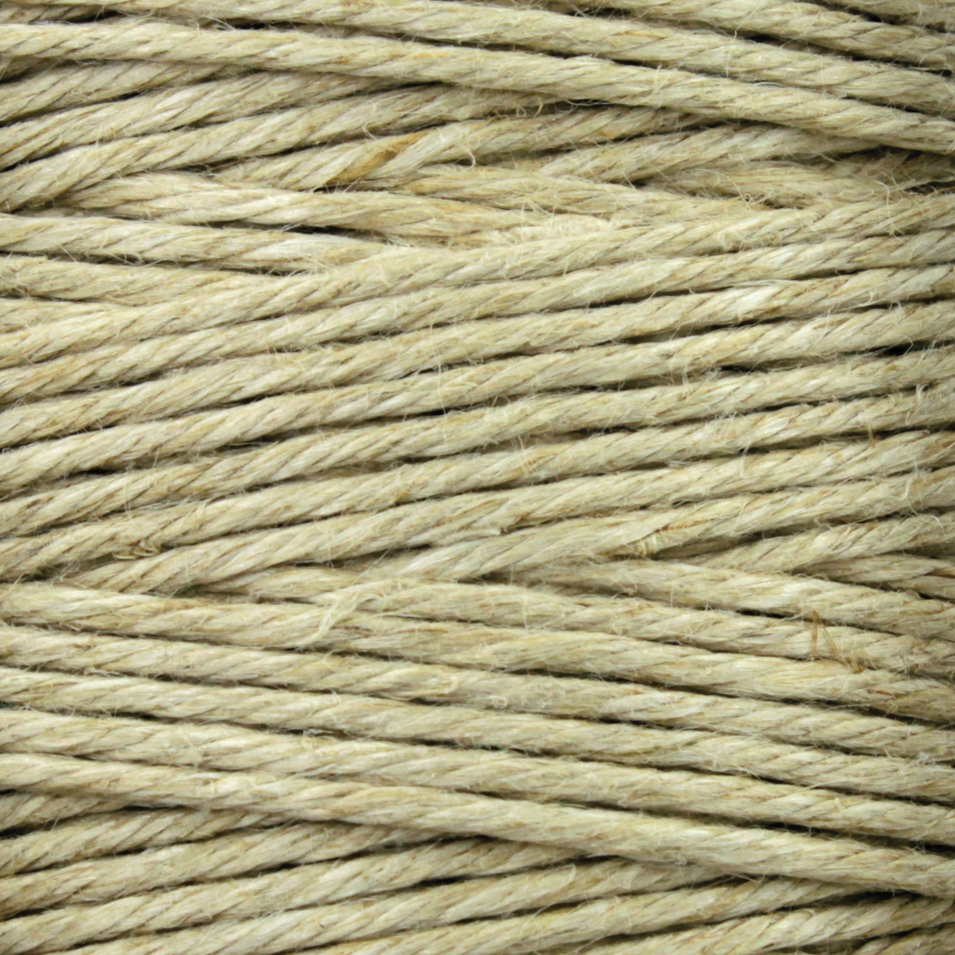 Close-up image of Soft Finish Linen Warps by Stuart C. Hurlbert & Co., coiled in a tightly packed bundle. The texture of the twine is coarse with visible fibers, reminiscent of linen warps used in Scandinavian rugs.