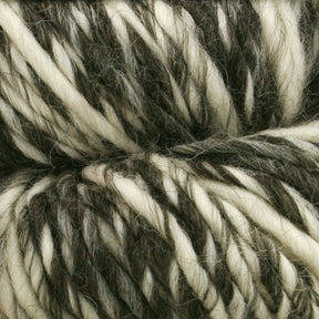 Close-up of a skein of Cascade Eco Duo Baby Alpaca and Merino Yarn by Cascade Yarns, showcasing a thick, intertwined pattern of black, white, and gray fibers. The yarn appears soft and fluffy, with the natural colors blending seamlessly throughout the twist.