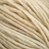 Close-up of soft, cream-colored Cascade Eco Duo Baby Alpaca and Merino Yarn strands tightly wound together. The texture appears smooth and slightly fluffy, indicating a cozy material suitable for knitting or crocheting projects. This yarn from Cascade Yarns is consistent in thickness and color, showcasing beautiful natural hues.