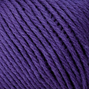 Close-up image of Brown Sheep's Cotton Fleece in purple, showcasing tightly wound strands with a slightly textured, fibrous surface. The yarn appears soft and thick, making it ideal for knitting or crocheting projects. The evenly spaced threads create a visually appealing, continuous pattern reminiscent of soft pastels.