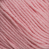 Close-up of Cotton Fleece by Brown Sheep, depicting the intricate texture of its soft and slightly twisted pink fibers. The uniform color throughout gives the yarn a smooth appearance, making it ideal for knitting patterns in soft pastels.