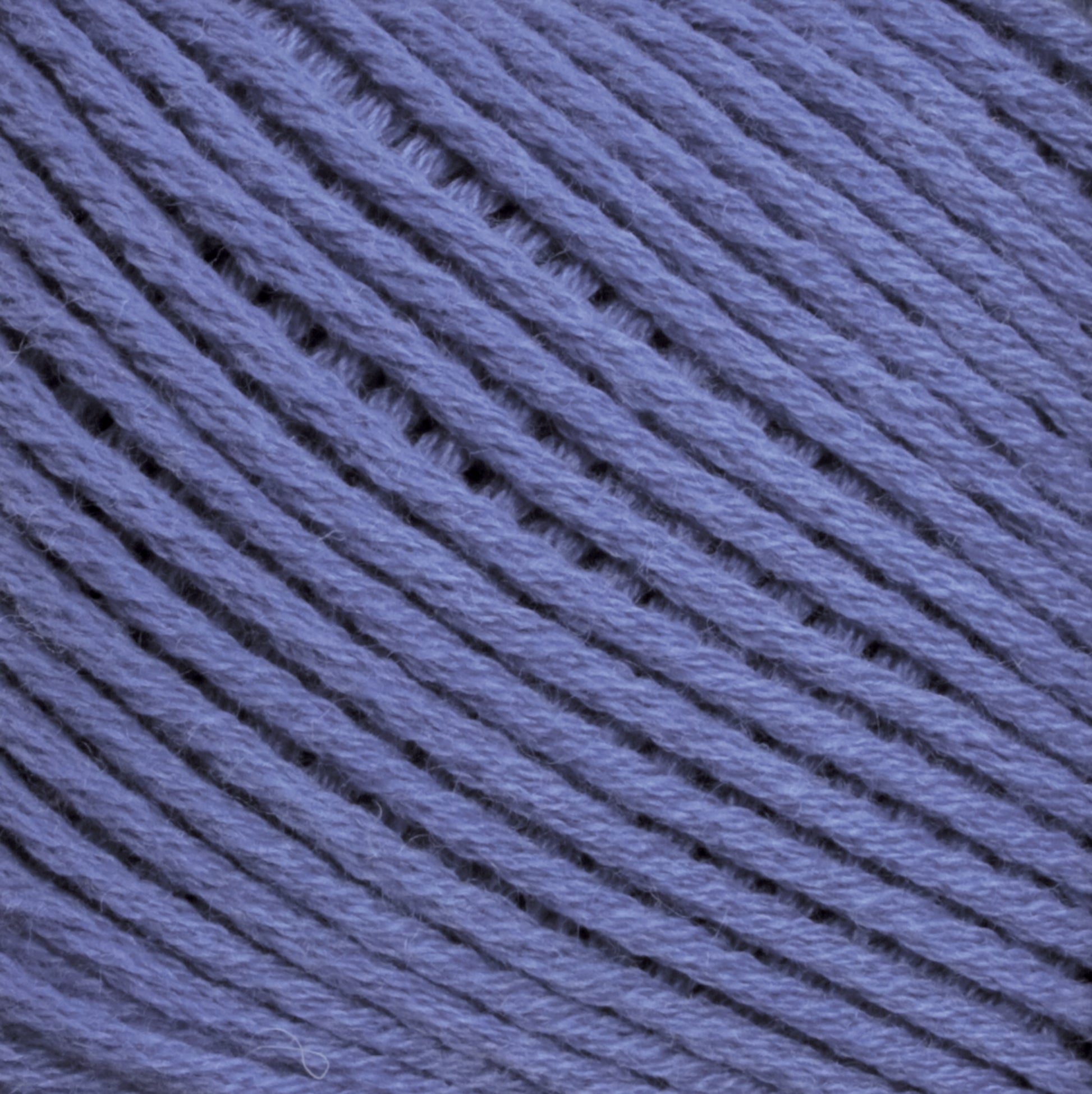 Close-up image of Brown Sheep Cotton Fleece in purple, showing the texture and individual fibers. The strands are arranged neatly in a parallel pattern, highlighting the smooth and slightly fuzzy surface of the yarn. This soft pastel-toned yarn is perfect for delicate knitting patterns.