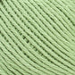 Close-up of a light green ball of Brown Sheep's Cotton Fleece yarn with tightly wound strands. The texture of the yarn is visible, showcasing the intertwined fibers, perfect for soft pastels in knitting patterns.