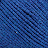 Close-up view of Brown Sheep's Cotton Fine blue cotton yarn strands tightly wound together. The texture and individual fibers of the yarn are clearly visible, showcasing the vibrant blue color and slightly varied hues within the strands—a perfect choice for machine knitters.