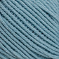 Close-up of a light blue Cotton Fine yarn ball from Brown Sheep, showcasing the tightly wound strands. The texture of the yarn is clearly visible, emphasizing its soft and fibrous nature ideal for machine knitters. The image focuses entirely on the Cotton Fine yarn, with no other objects or background in sight.