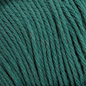 Close-up image of Brown Sheep's Cotton Fine yarn in teal. The yarn threads, tightly wound together, display a soft texture and consistent color. The fibers are slightly fluffy, perfect for weaving projects or machine knitters seeking high-quality material.