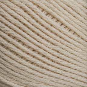 Close-up image of a ball of Cotton Fine yarn by Brown Sheep, showcasing the texture and tight weaving of the fibers. The yarn appears soft, with neatly arranged strands creating a diagonal pattern across the frame—a perfect choice for machine knitters.