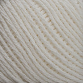 Close-up of a ball of Brown Sheep's Cotton Fine yarn in cream, highlighting its texture and tightly wound individual strands, ideal for weaving or machine knitting.