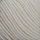 Close-up of a ball of Brown Sheep's Cotton Fine yarn in cream, highlighting its texture and tightly wound individual strands, ideal for weaving or machine knitting.