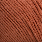 Close-up image of Brown Sheep's Cotton Fine yarn in orange, showcasing its tightly wound fibers. The texture is soft and the color is consistent throughout the strands, making it ideal for knitting, crocheting, or machine knitting.