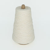 A large spool of off-white Cotton Fine yarn by Brown Sheep is shown against a plain white background, tightly wound around a brown cone-shaped base.