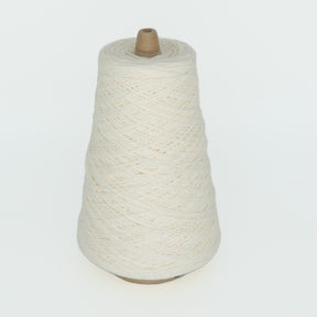 A large spool of off-white Cotton Fine yarn by Brown Sheep is shown against a plain white background, tightly wound around a brown cone-shaped base.