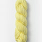 A skein of Blue Sky Fibers Organic Cotton Worsted, made from soft, pale yellow organic cotton yarn, tightly wound and twisted into a cylindrical shape, positioned vertically against a plain white background. The worsted weight yarn by Blue Sky Fibers appears thick and smooth, making it ideal for knitting or crocheting baby knits.