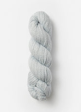 A neatly coiled skein of Blue Sky Fibers Organic Cotton Worsted yarn in light gray is displayed against a clean white background. The yarn, from Blue Sky Fibers, has a thick and chunky texture, making it suitable for knitting or crocheting projects that require bulky yarn, perfect for cozy baby knits.