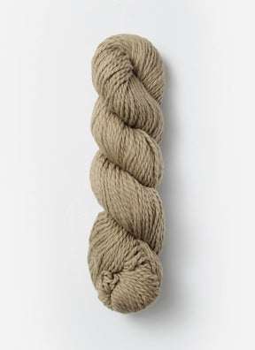 A neatly twisted skein of Blue Sky Fibers Organic Cotton Worsted yarn against a plain white background. The beige, worsted weight yarn from Blue Sky Fibers has a soft, slightly textured appearance, making it perfect for knitting or crocheting baby knits.