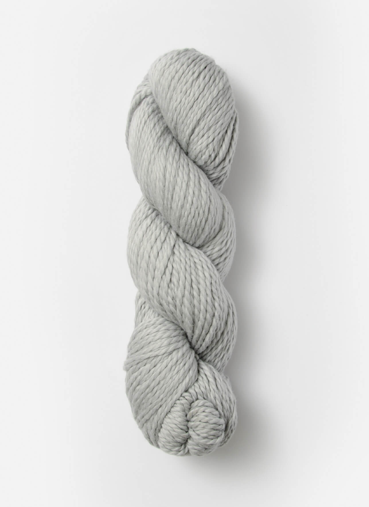 A neatly twisted skein of Blue Sky Fibers Organic Cotton Worsted in light gray is shown against a plain white background. The yarn appears thick and soft, suitable for knitting or crocheting projects, including cozy baby knits.