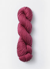 A skein of Blue Sky Fibers Organic Cotton Worsted yarn in a rich, burgundy color is displayed against a plain white background. The yarn appears soft and plush, making it perfect for baby knits or other cozy projects.