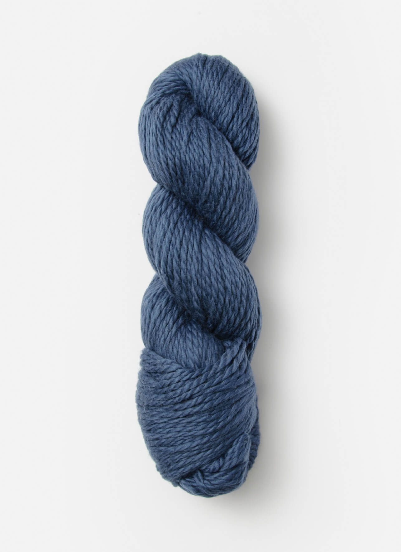 A skein of Blue Sky Fibers Organic Cotton Worsted in dark blue is neatly wound in a twisted bundle against a plain white background. The texture of the Blue Sky Fibers worsted weight yarn appears soft and slightly thick, making it ideal for knitting or crocheting projects, especially baby knits.