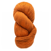 A skein of eco-friendly, orange Cascade Eco and Cascade Eco Plus Wool Yarn from Cascade Yarns, made from Peruvian Highland wool, is tightly coiled against a white background.