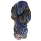 A skein of Malabrigo Rasta by Malabrigo Yarn features a lavish, super bulky merino wool yarn in shades of blue, purple, brown, and green. Its thick strands are loosely twisted into a large coil and beautifully presented on a white background.