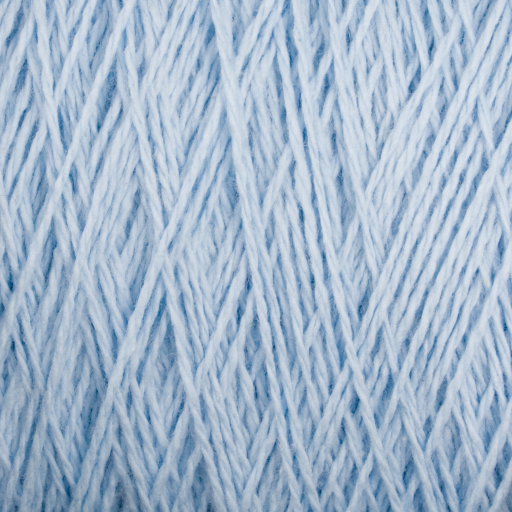 Close-up image of Homestead 8/2 Cotton Yarn from Supreme Corp in light blue, intricately woven together to create a dense, textured pattern. The versatile yarns are twisted and intertwined, forming a complex, uniform design that highlights the subtle variations in color and thickness.