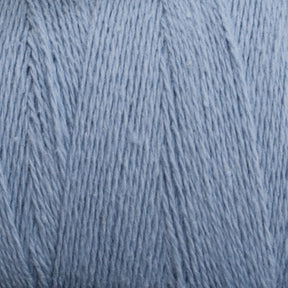 Close-up of a ball of Homestead 8/2 Cotton Yarn | Mini-cone by Supreme Corp in light blue, machine-washable yarn, showing the detailed texture of the fibers. The yarn is neatly wound, displaying a soft and smooth surface with fine strands intertwined together.