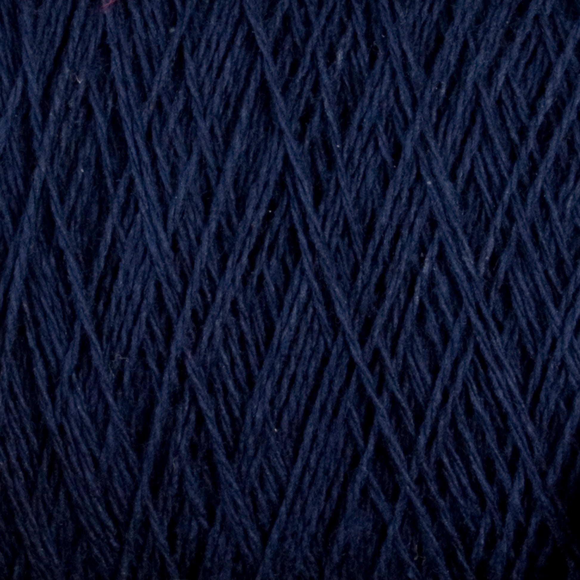 Close-up image of dark blue Homestead 8/2 Cotton Yarn by Supreme Corp, machine-washable and wrapped tightly in a mini-cone, showcasing its intricate and textured pattern.