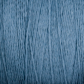 Close-up image of the soft, light blue Homestead 8/2 Cotton Yarn on a mini-cone by Supreme Corp. The fibers appear smooth and polished, with visible strands running vertically, suggesting a tightly wound skein of versatile yarns ready for knitting or other textile crafts.