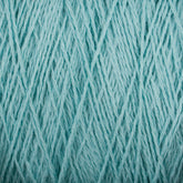 Close-up image of Homestead 8/2 Cotton Yarn | Mini-cone in light blue from Supreme Corp, tightly wound into a ball. The strands of this versatile yarn create a textured and intricate pattern of intertwining fibers across the entire frame. The overall appearance is soft and detailed.