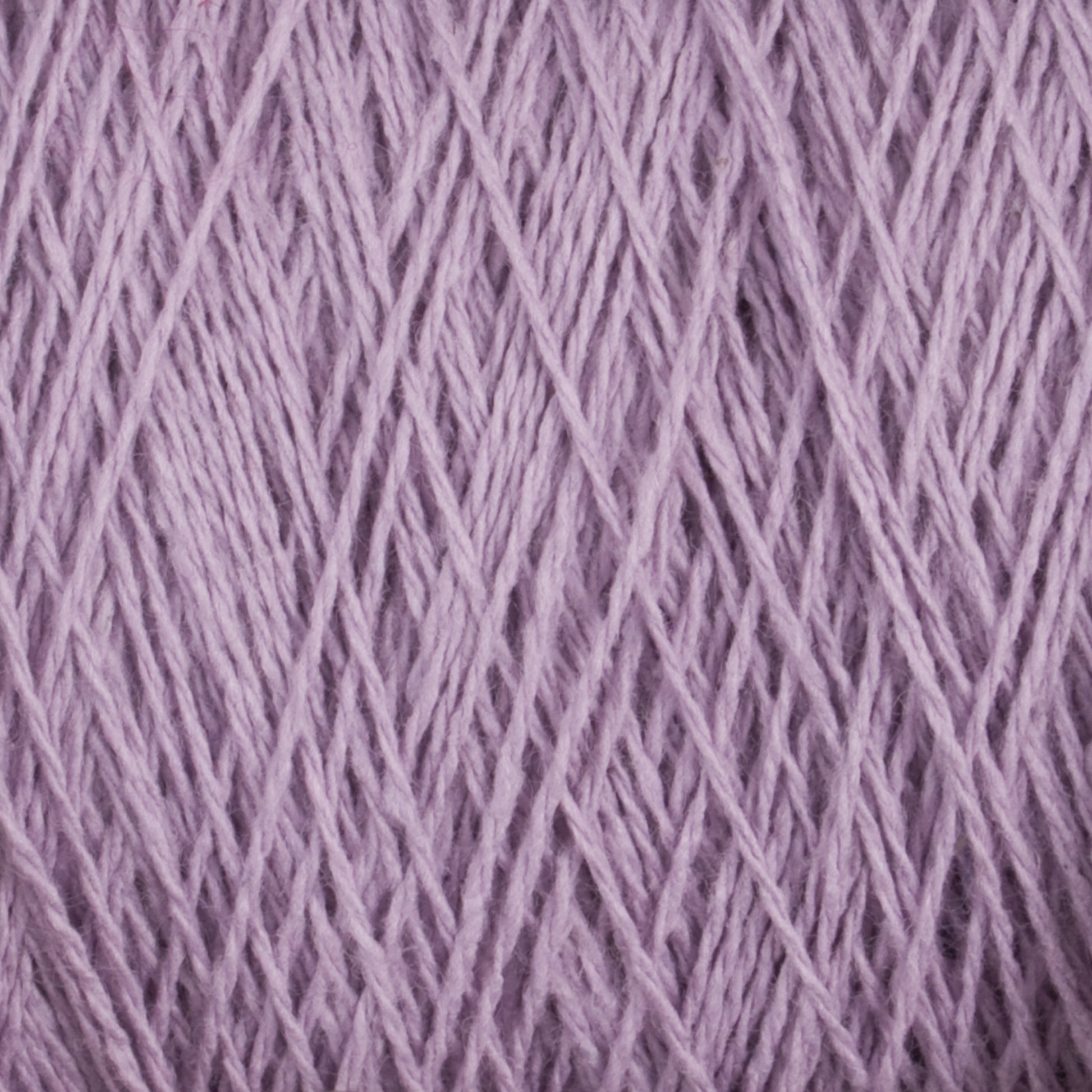 Close-up image of Homestead 8/2 Cotton Yarn in a lovely lavender hue from Supreme Corp, intricately woven together and filling the frame. The versatile fibers on the mini-cone appear soft and slightly fuzzy, showcasing the texture and detail of this beautiful weaving yarn.