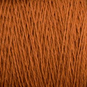 Close-up view of Supreme Corp's Homestead 8/2 Cotton Yarn in orange-brown, with a soft and slightly fuzzy texture. The machine-washable fibers are neatly aligned, showcasing the detailed strands and slight color variations that evoke warmth and coziness.