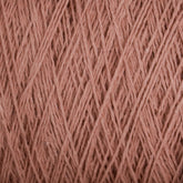 A close-up view of a bundle of Supreme Corp's Homestead 8/2 Cotton Yarn on a large cone in a dusty pink color. The strands are tightly wound, creating a textured and slightly fuzzy appearance. This yarn, ideal for weaving projects, showcases intricate fibrous details and the rich, soft hue that is also machine-washable.