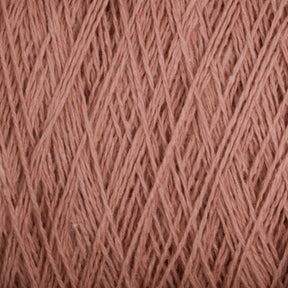 Close-up image of a spool of Homestead 8/2 Cotton Yarn | Mini-cone by Supreme Corp, showcasing the intricate patterns and textures of the pink fibers. The versatile yarn appears soft and slightly fuzzy, with light and shadow highlighting the individual strands.