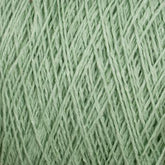 Close-up of a spool of pale green Homestead 8/2 Cotton Yarn from Supreme Corp. The yarn strands are tightly wound, creating a crisscross pattern. The texture appears soft and lightweight, ideal for knitting or crocheting delicate garments or accessories. This weaving yarn comes on a large cone and is also machine-washable for added convenience.