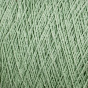 Close-up of Homestead 8/2 Cotton Yarn in light green, wound tightly. The image showcases the texture and fibrous detail of this versatile yarn from Supreme Corp, highlighting its soft and intertwined appearance. The consistent green hue throughout suggests a single, continuous piece of machine-washable yarn on this mini-cone.