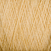 A close-up image of tightly wound, pale yellow Homestead 8/2 Cotton Yarn from Supreme Corp. The strands are uniformly arranged and showcase a soft, textured appearance, suitable for knitting or crafting. This machine-washable yarn features a consistent color throughout, giving it a warm, creamy look.