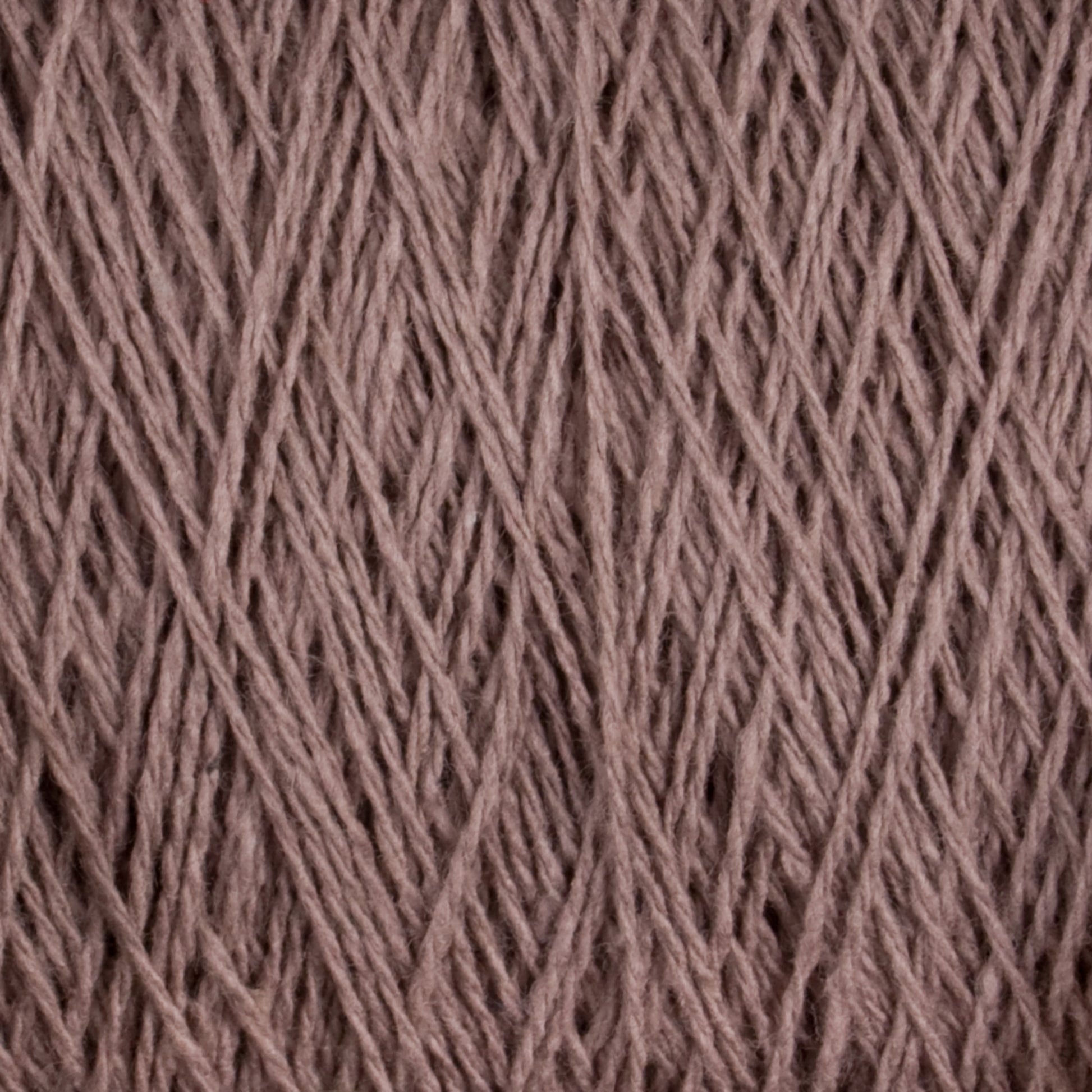 Close-up image of a mini-cone of Homestead 8/2 Cotton Yarn from Supreme Corp, showcasing its tightly wound brown fibers and slightly varied texture. The crisscross pattern of the yarn threads is clearly visible, creating an intricate, woven appearance. The color is a warm, muted brown and the yarn is machine-washable.