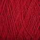 Close-up view of a textured red yarn. The strands are interwoven, showcasing the intricate weaving pattern. This Supreme Corp Homestead 8/2 Cotton Yarn | Large Cone focuses on the rich, solid red color and its fine, slightly fuzzy texture, all while being machine-washable for your convenience.