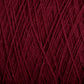 Close-up image of deep maroon, machine-washable Homestead 8/2 Cotton Yarn by Supreme Corp, tightly wound with visible strands and fibers. The texture showcases intricate details of the individual threads crossing and interweaving, forming a dense and uniform pattern.