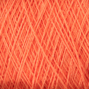 Close-up image of a tightly wound ball of coral-colored, versatile yarn. The thin strands of Homestead 8/2 Cotton Yarn from Supreme Corp are densely packed, creating a textured pattern of intersecting lines and subtle shadows, perfect for weaving projects.