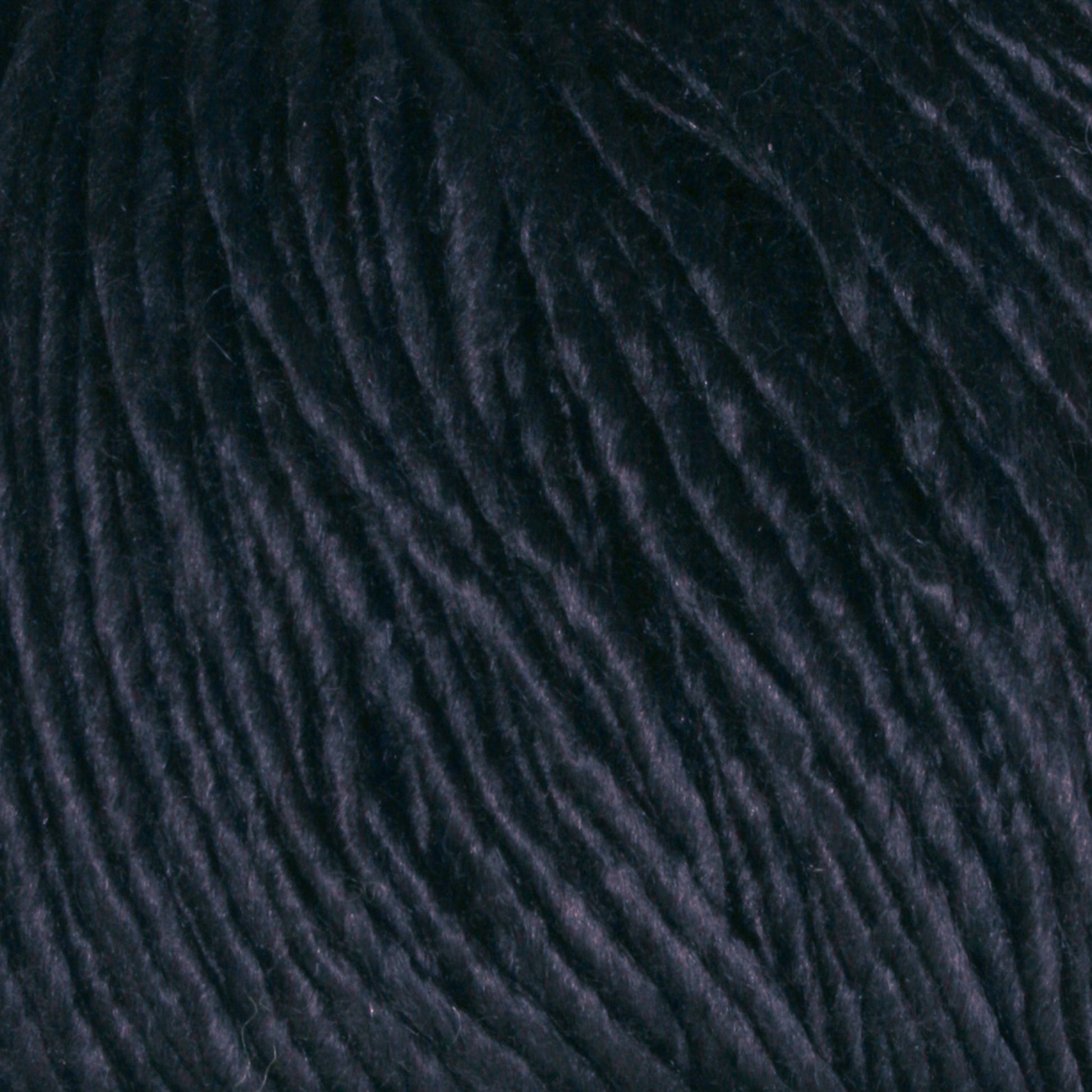 Close-up of Halcyon Yarn's Gemstone Soft Twist Silk Yarn. The tightly twisted strands showcase the thickness and fibrous nature of the yarn. The image highlights the soft, slightly shiny surface of the silk, emphasizing its smooth and well-spun quality similar to gemstone silks.