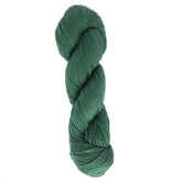 A skein of Halcyon Yarn's Gemstone Soft Twist Silk Yarn, in dark green, is coiled neatly, forming an elongated oval shape. The 100% silk yarn has a smooth texture and is tightly twisted, showcasing its thickness and soft fibers against a solid white background.