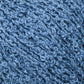 Close-up image of Halcyon Yarn’s Gemstone Silk Bouclé showing the blue textured yarn with a curly appearance. The yarn features a shiny, almost reflective quality and tightly looped fibers, giving it a richly textured and soft look. The vibrant, uniform blue color is reminiscent of gemstone silks.