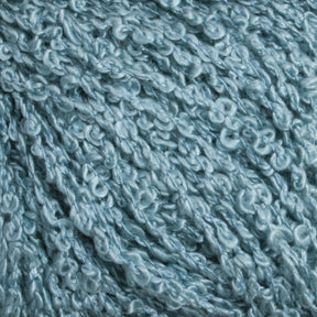 Close-up of light blue Gemstone Silk Bouclé yarn by Halcyon Yarn showing its textured, looped surface. The yarn has a soft, slightly shiny appearance, with small, curly loops creating a bumpy and intricate pattern.