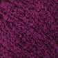 Close-up of Halcyon Yarn's Gemstone Silk Bouclé. The surface appears soft and fluffy with tightly wound fibers creating a rich, intricate pattern. Reminiscent of Gemstone Silk Bouclé, the deep hue of the purple adds to the detail and depth of the material.